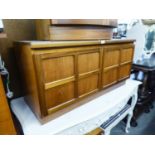 A NATHAN, TEAK LOW SMALL CUPBOARD, ENCLOSED BY TWO FOUR PANEL DOORS