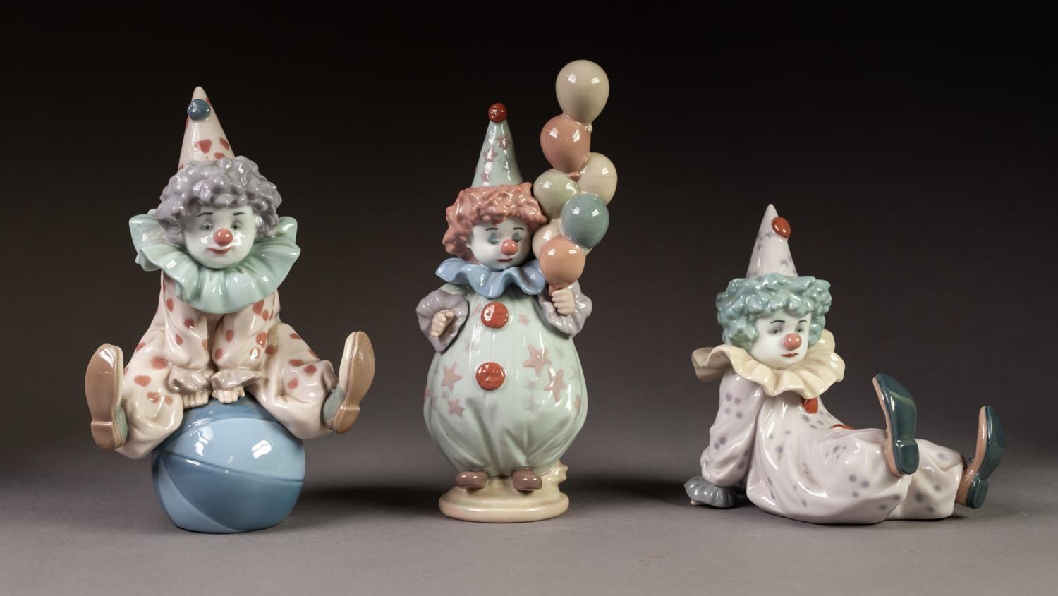 THREE LLADRO PORCELAIN FIGURES OF CLOWNS, one modelled lying down, another standing, holding