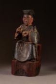 NINETEENTH CENTURY CHINESE CARVED SOFTWOOD FIGURAL PRAYER HOLDER, painted in colours and modelled as