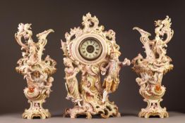 A CIRCA 1900 GERMAN PORCELAIN ROCOCO REVIVAL THREE PIECE CLOCK GARNITURE,  each of scrolliated