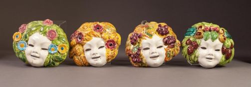 SET OF FOUR LATE NINETEENTH CENTURY CONTINENTAL MAJOLICA POTTERY SMALL WALL MASKS, possibly