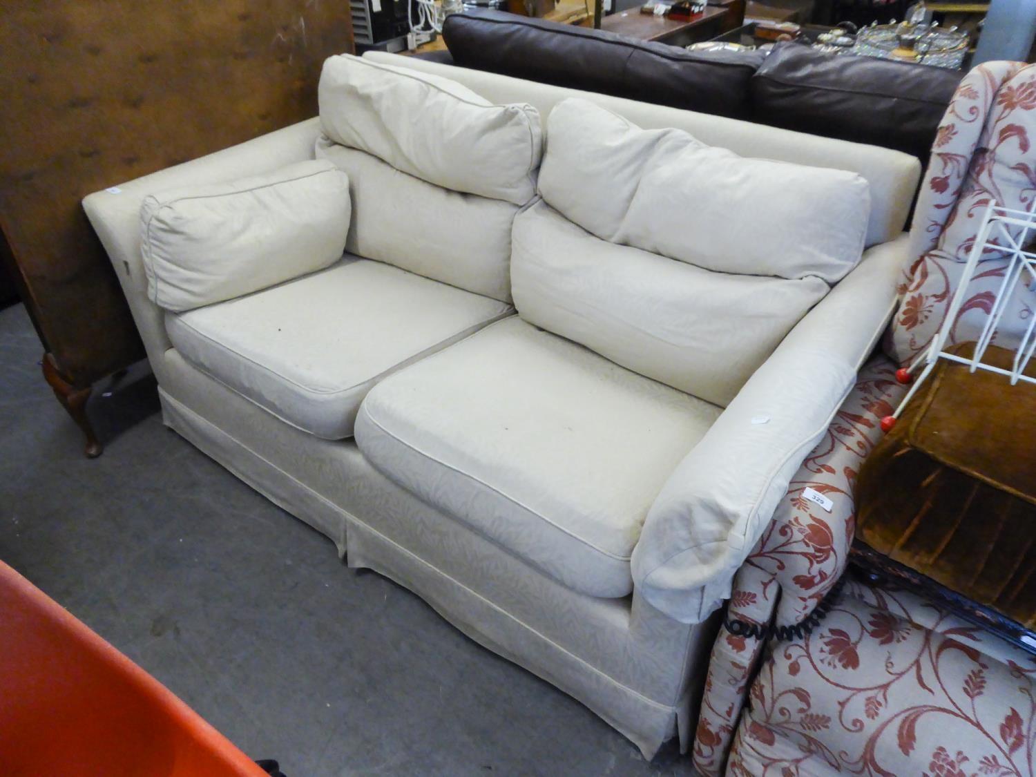 A WESLEY BARREL TWO SEATER SETTEE COVERED IN BEIGE FABRIC