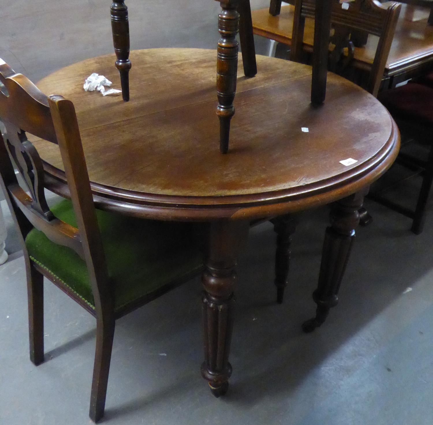 AN EARLY VICTORIAN MAHOGANY CIRCULAR EXTENDING DINING TABLE ON FOUR TURNED AND LOBED TAPERING