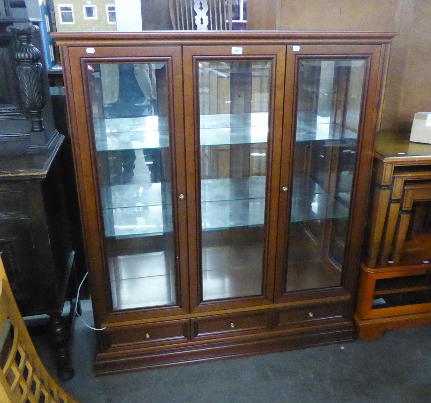 A MAHOGANY DISPLAY CABINET WITH CENTRE GLAZED PANEL, FLANKED BY TWO GLAZED DOORS, ON PLINTH BASE