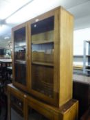 A WALNUTWOOD DWARF BOOKCASE WITH TWO GLAZED DOORS