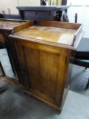 AN OAK DWARF CUPBOARD OR MUSIC CABINET WITH ¾ GALLERY BACK, FRAMED PANEL DOOR ENCLOSING TWO SHELVES,