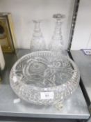 TWO CUT GLASS WINE DECANTERS AND STOPPERS AND A LARGE CUT GLASS FRUIT BOWL, RAISED ON THREE SCROLL