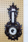 AN ANEROID BAROMETER AND THERMOMETER IN FOLIATE CARVED CASE