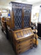 JACOBEAN STYLE OAK BUREAU BOOKCASE, THE UPPER PORTION WITH TWO LEAD LIGHT DOORS, THE LOWER PORTION