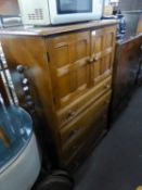 A JACOBEAN STYLE OAK MILLINERY CABINET, WITH CUPBOARD OVER FOUR LONG DRAWERS, ON BALL FEET