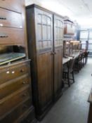 AN OAK CHEST OF FIVE LONG DRAWERS WITH WOOD KNOB HANDLES AND A MATCHING TWO DOOR WARDROBE