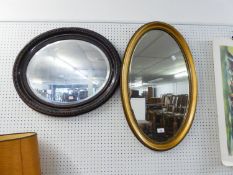 A GILT FRAMED OVAL MIRROR AND A MAHOGANY FRAMED OVAL WALL MIRROR (2)