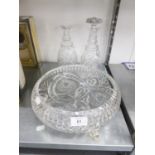 TWO CUT GLASS WINE DECANTERS AND STOPPERS AND A LARGE CUT GLASS FRUIT BOWL, RAISED ON THREE SCROLL