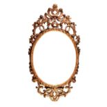 TWENTIETH CENTURY CARVED GILT WOOD WALL MIRROR, the later oval plate housed in a gadroon moulded