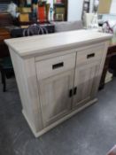 A LIMED OAK FINISH MODERN SIDE CABINET WITH TWO DRAWERS OVER A CUPBOARD WITH TWO DOORS, OBLONG