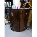 AN ANTIQUE OAK BOW FRONTED CORNER CUPBOARD