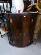 AN ANTIQUE OAK BOW FRONTED CORNER CUPBOARD