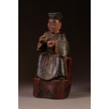 NINETEENTH CENTURY CHINESE CARVED SOFTWOOD FIGURAL PRAYER HOLDER, painted in colours and modelled as