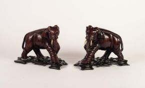 WELL CARVED REDWOOD PAIR OF ELEPHANTS, with bone tusks and glass eyes, on pierced blackwood bases, 6