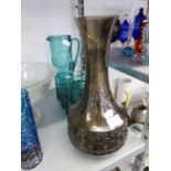 A LARGE PURPLE GLASS LONG NECKED VASE, THE STRAIGHT SIDED LOWER PORTION HAVING EMBOSSED PATTERN,