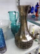 A LARGE PURPLE GLASS LONG NECKED VASE, THE STRAIGHT SIDED LOWER PORTION HAVING EMBOSSED PATTERN,