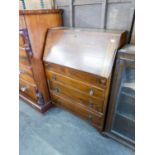 AN OAK BUREAU WITH THREE LONG DRAWERS BELOW