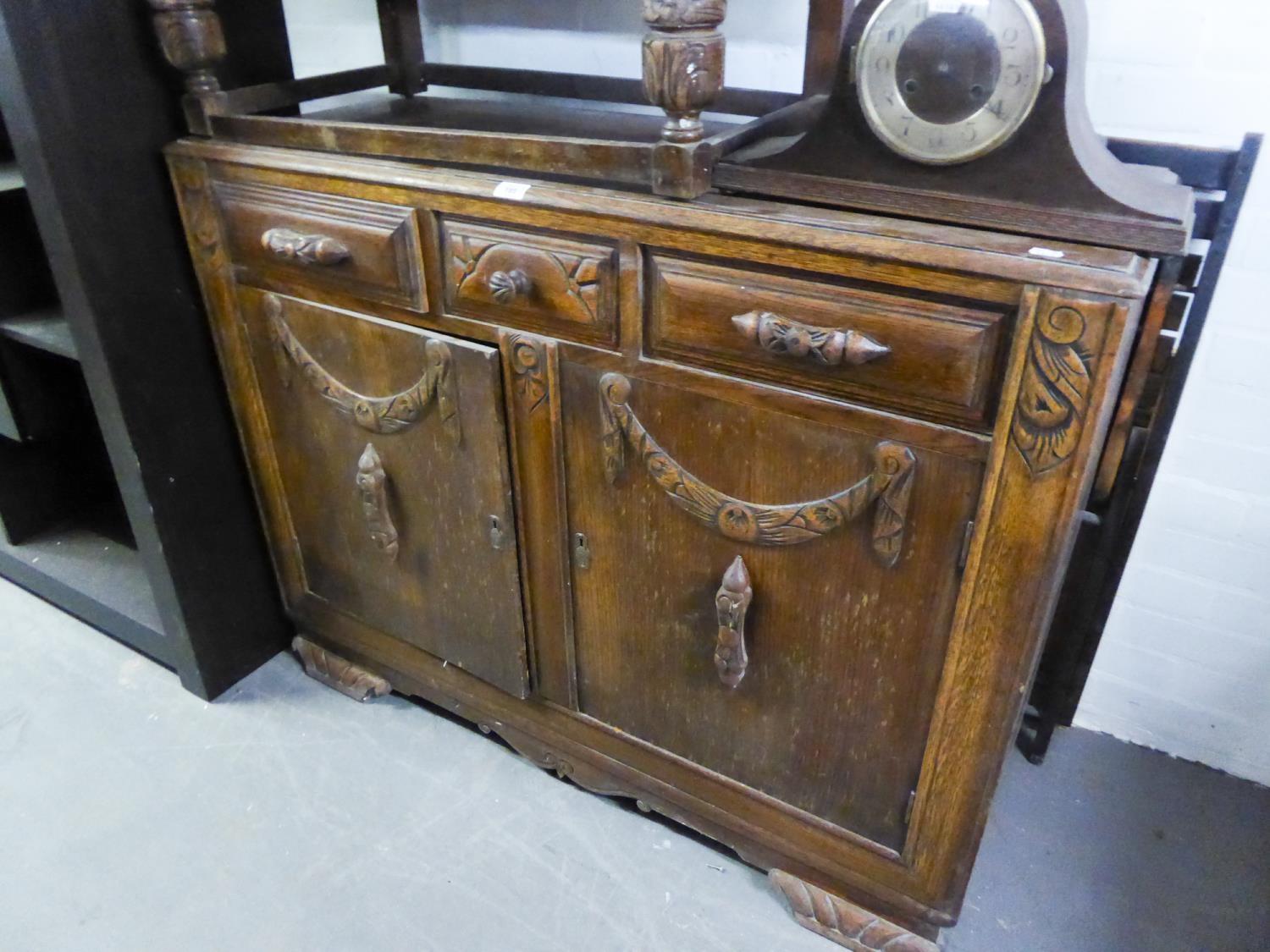 1950's CARVED OAK ENCLOSED SIDEBOARD, WITH THREE DRAWERS OVER A CUPBOARD WITH TWO DOORS