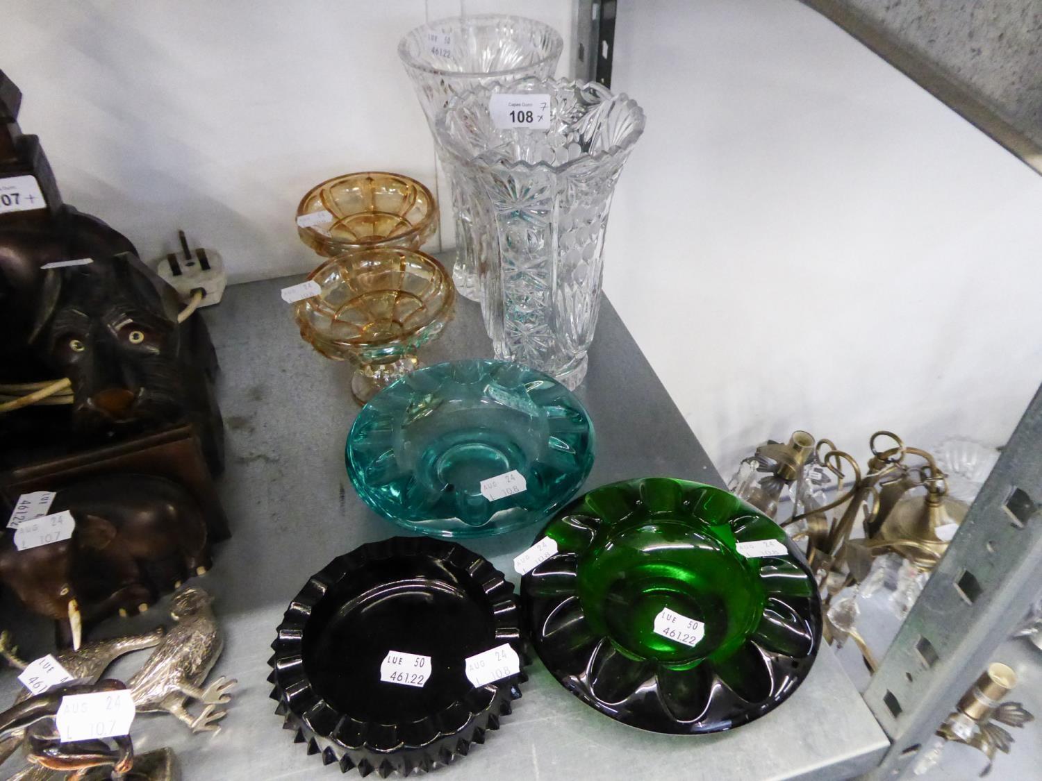 A CUT GLASS FLOWER VASE; A MOULDED GLASS FLOWER VASE; THREE HEAVY COLOURED GLASS ASHTRAYS AND A PAIR