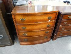 AN INTER-WAR YEARS GERMAN BOW FRONTED CHEST OF FOUR DRAWERS WITH BRASS BACK PLATE HANDLES