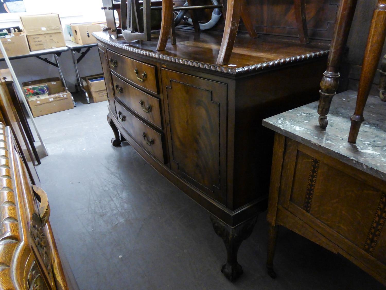 AN EDWARDIAN MAHOGANY BOW FRONT SIDEBOARD, HAVING TWO CUPBOARD DOORS, THREE CENTRAL DRAWERS ON