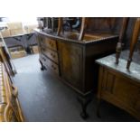 AN EDWARDIAN MAHOGANY BOW FRONT SIDEBOARD, HAVING TWO CUPBOARD DOORS, THREE CENTRAL DRAWERS ON
