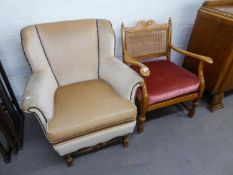 AN UPHOLSTERED ARMCHAIR, COVERED IN BEIGE VELOUR WITH STUDDED FINISH, RAISED ON WOODEN TURNED BASE