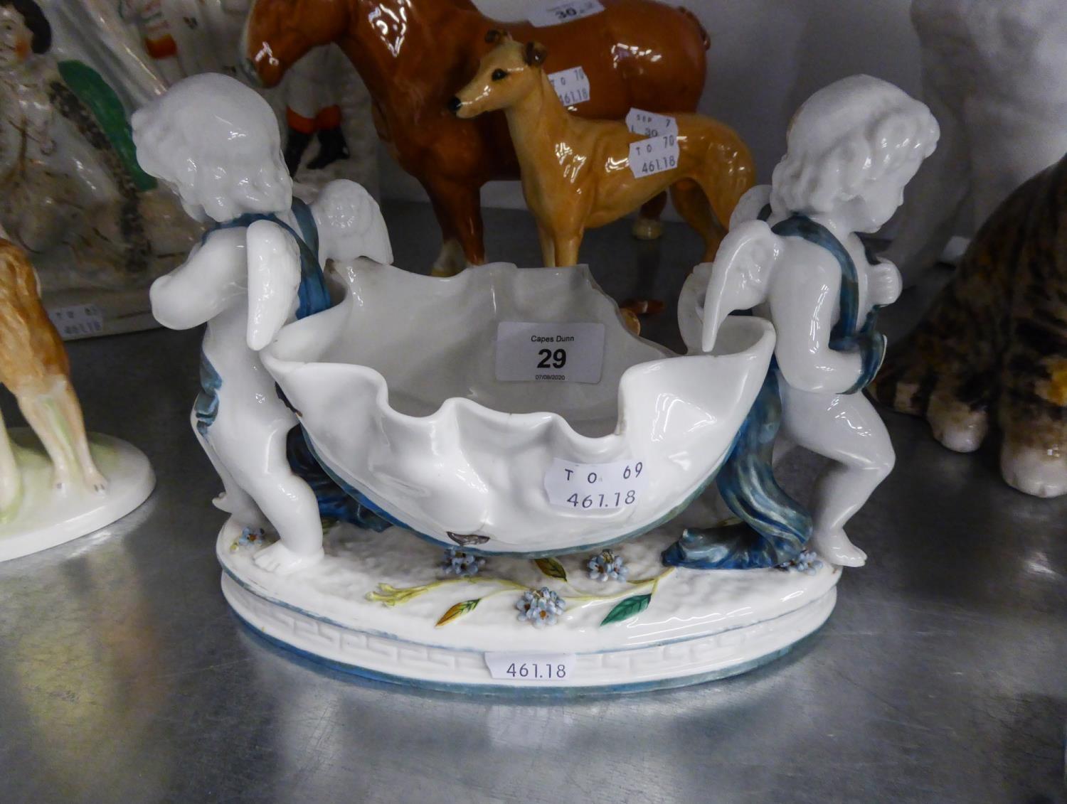 19TH CENTURY MOORE CHINA BOWL SUPPORTED AT EACH END BY A CHERUB, ON OVAL BASE, (STITCHED REPAIR)