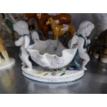 19TH CENTURY MOORE CHINA BOWL SUPPORTED AT EACH END BY A CHERUB, ON OVAL BASE, (STITCHED REPAIR)