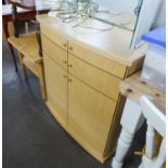 A PALE BEECH, SLIGHTLY BOW FRONTED CABINET WITH TWO LONG DRAWERS OVER A CUPBOARD WITH TWO DOORS