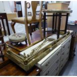 A BRASS FIRE FENDER (138cm long), FOUR BRASS FIRE IMPLEMENTS AND A CIRCULAR BRASS TOP TABLE ON