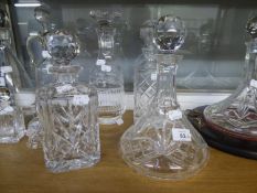 A CUT GLASS SHIP?S DECANTER; TWO SQUARE SPIRIT DECANTERS; CUT GLASS WINE DECANTER WITH LARGE