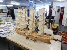 A LARGE WOODEN SHIP WITH FOUR MASTS ON STAND