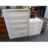 A CREAM CHEST OF FOUR DRAWERS AND A WHITE PAINTED OPEN BOOKCASE (2)