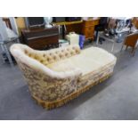 A CHAISE LONGUE WITH CURVED END, COVERED IN GOLD FABRIC