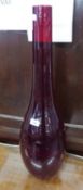 A LARGE RED GLASS BULB SHAPED VASE (APPROX 70cm HIGH)