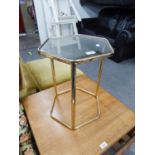 A BRASS FRAMED HEXAGONAL COFFEE TABLE WITH INSET GLASS TOP, THREE STRAIGHT LEGS SUPPORT ON THE FLOOR