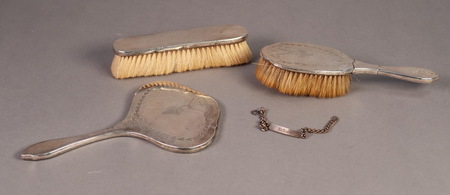 GEORGE V SILVER BACKED DRESSING TABLE HAND MIRROR AND MATCHING HAIRBRUSH, engraved with floral
