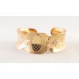 TWO-COLOUR GOLD COLOURED METAL OPEN BANGLE, broad and concave with scolloped borders, the matt