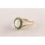 9ct GOLD, OPAL AND EMERALD OVAL CLUSTER RING set with a centre oval opal and surround of fourteen