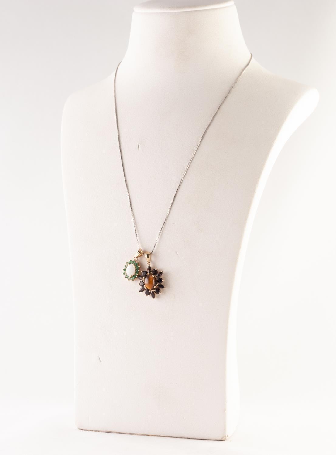 9ct GOLD, TIGER'S EYE AND GARNET OVAL PENDANT set with a cabochon tiger's eye and surround of twelve