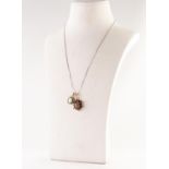 9ct GOLD, TIGER'S EYE AND GARNET OVAL PENDANT set with a cabochon tiger's eye and surround of twelve