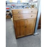 A LIGHT OAK MILLINERY CABINET WITH TWO LONG DRAWERS OVER TWO DOORS