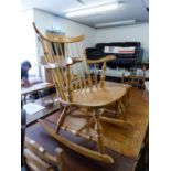 A LIGHTWOOD OPEN ARM ROCKING CHAIR, WITH STICK BACK AND SOLID WOODEN SEAT