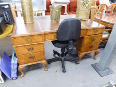 A WALNUT KNEEHOLE DESK WITH INLET LEATHER TOP, SEVEN DRAWERS, ON EIGHT SHELL CARVED CABRIOLE